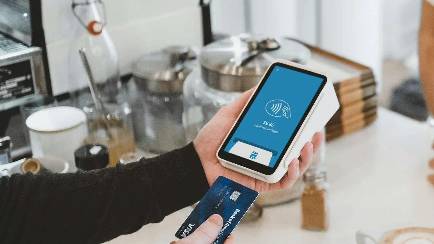 Customer paying with a card at a coffee shop POS terminal